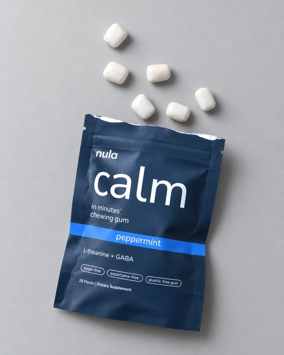 An open Nula calm gum pouch with pieces of gum beside it